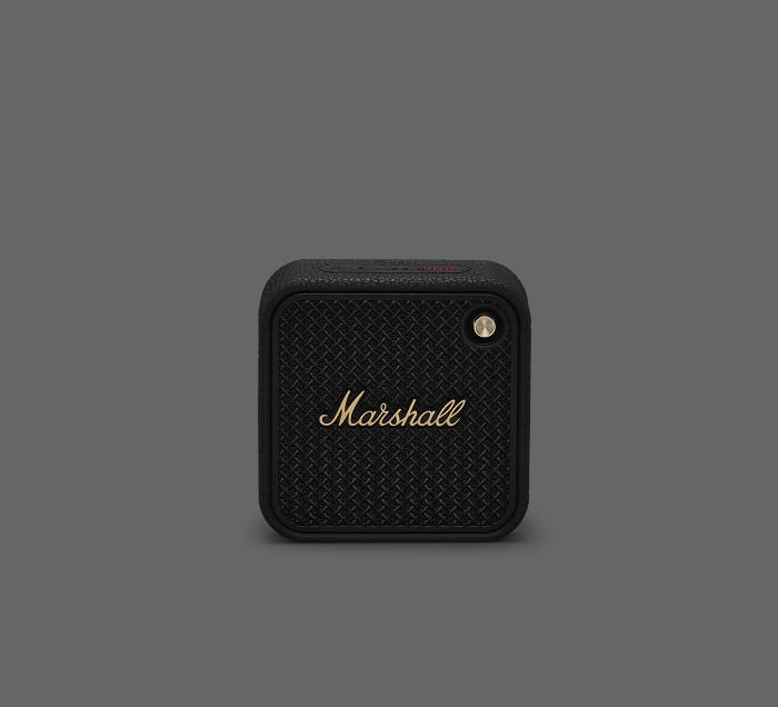 Marshall Willen II Bluetooth-Lautsprecher in quadratischem Design mit goldenen Akzenten auf grauem Hintergrund.