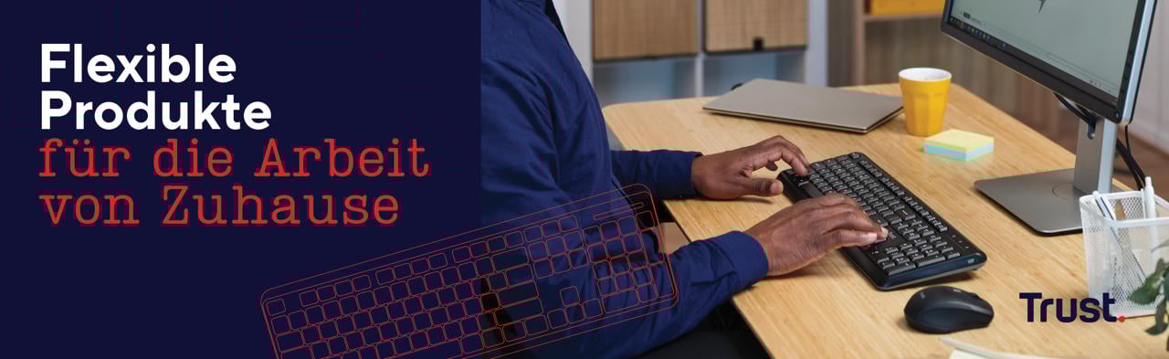 Person arbeitet am Schreibtisch mit Trust Tastatur und Maus, daneben Laptop und Monitor – Text „Flexible Produkte für die Arbeit von Zuhause“.