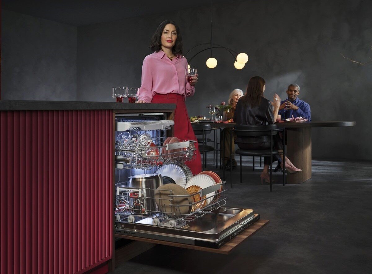 Moderne Küche mit geöffnetem AEG Geschirrspüler und elegant gedecktem Esstisch im Hintergrund – stilvolles Design trifft Leistung.