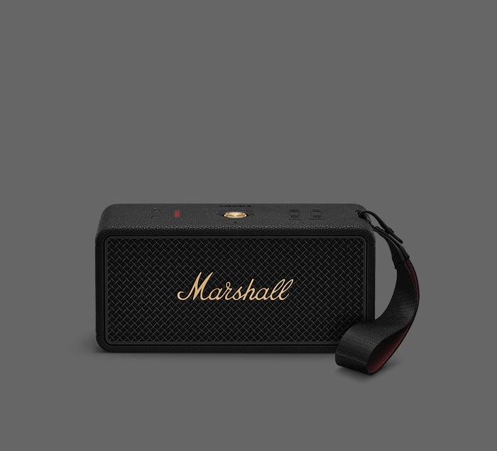 Marshall Middleton II Bluetooth-Lautsprecher in Schwarz mit Trageschlaufe und goldenen Bedienelementen auf grauem Hintergrund.