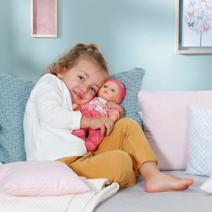 Abbildung Die kleine weiche Puppe mit Schlafaugen bringt ihr Fläschchen für erstes Eltern-Kind-Rollenspiel mit