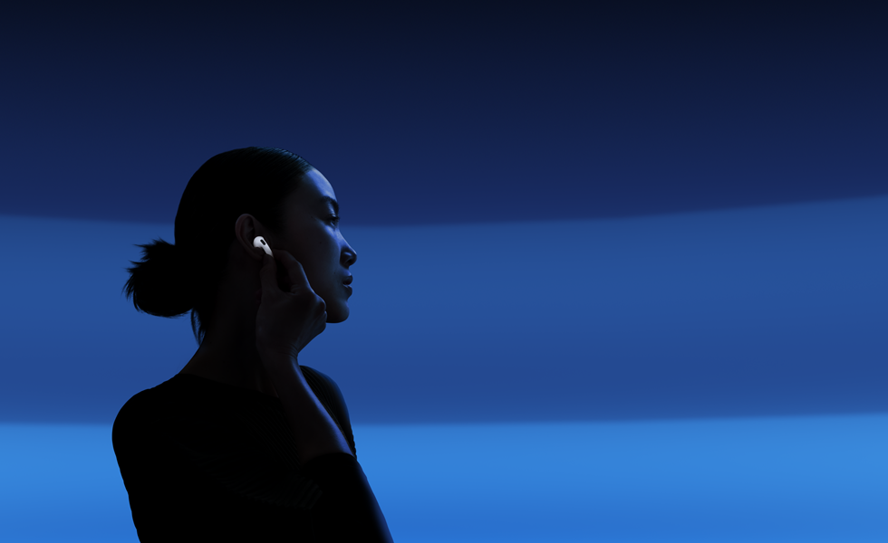 Eine Person hält das untere Ende ihrer AirPods 5 zwischen Daumen und Zeigefinger, um den Hörmodus zu wechseln