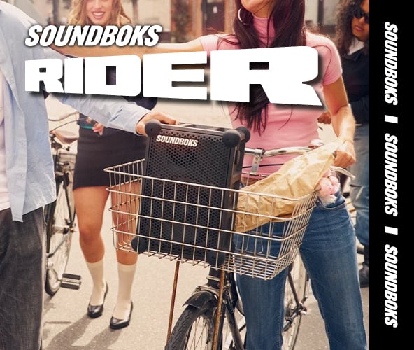 Der Hinweis zum Thema Soundboks outdoor Bluetooth-Speaker. Feiernde Menschen und vor ihnen steht die Soundboks in einem Einkaufswagen. 
